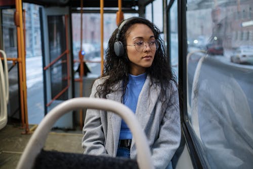 A Woman Riding a Bus Wearing Headphones