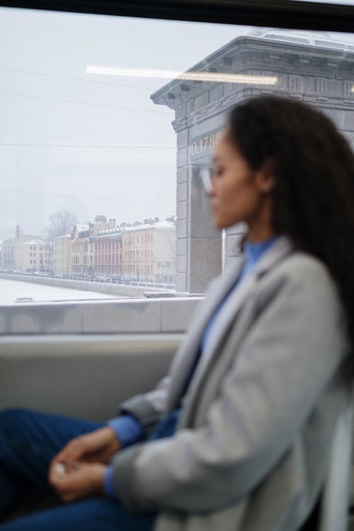 A Woman Sitting Beside the Glass Window