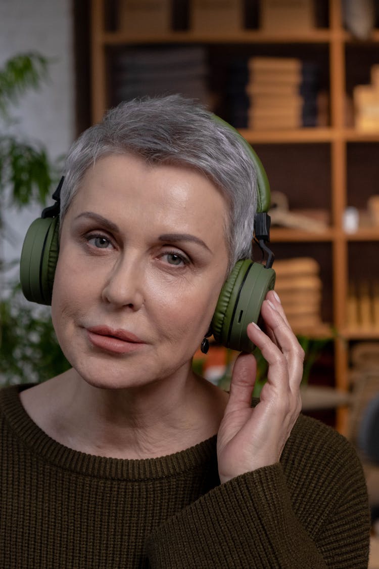 A Woman Listening To A Headphone