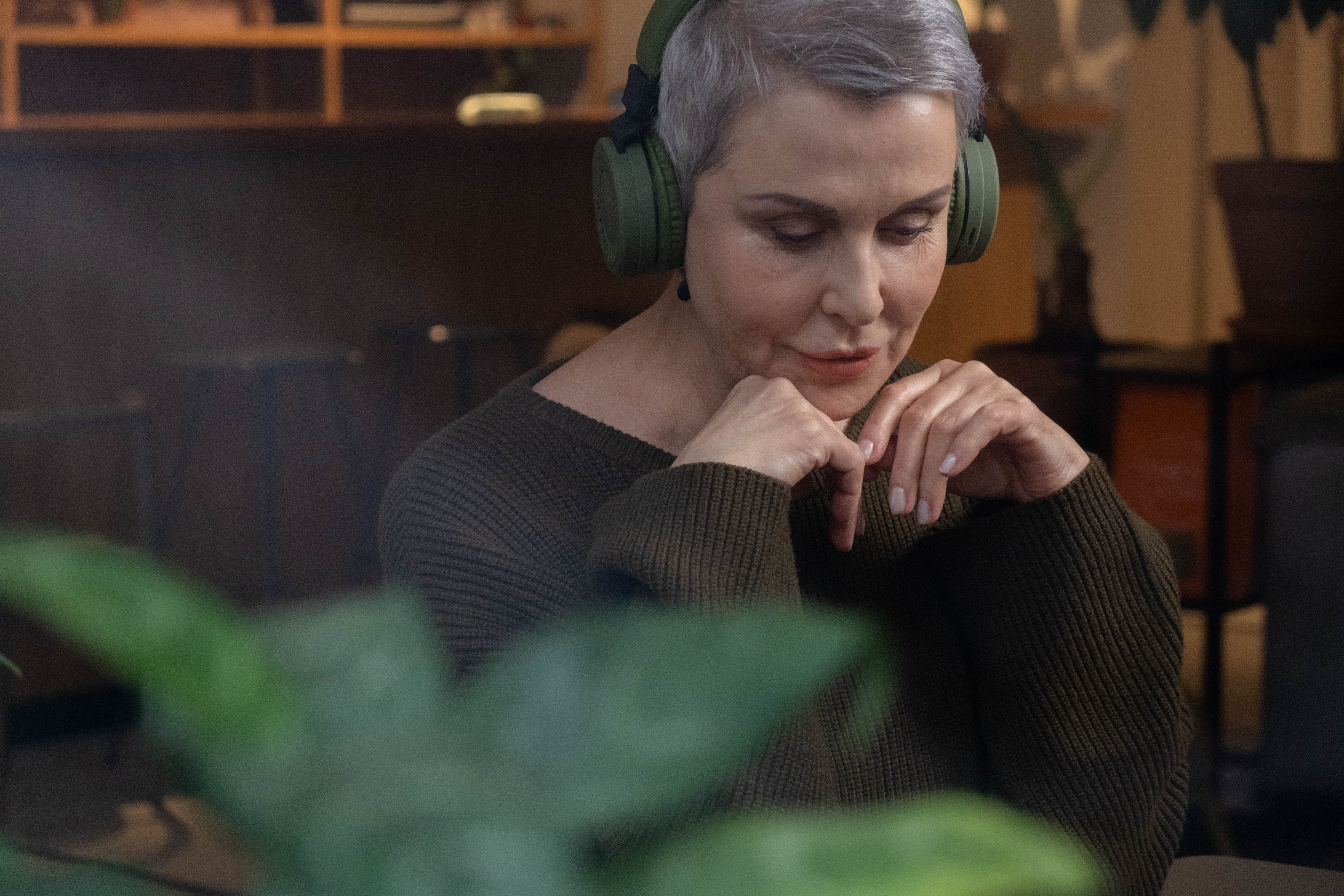 person wearing headphones listening to music with thoughtful expression
