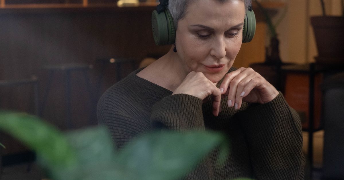 person wearing headphones listening to music with thoughtful expression