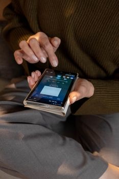 Close-up of woman using smartphone to navigate music app indoors.