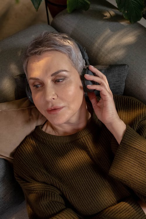 Free Woman in Brown Sweater Wearing Headphones Stock Photo