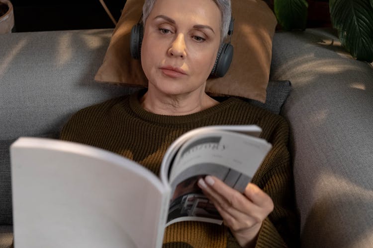 Woman Reading Magazine On A Bed 