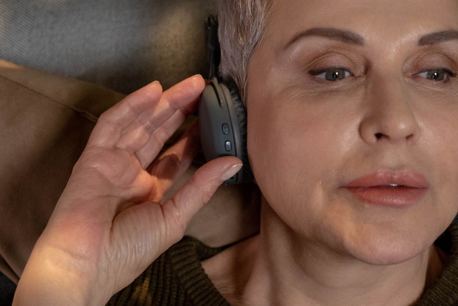 An elderly woman listening to music with headphones An elderly woman listening to music with headphones