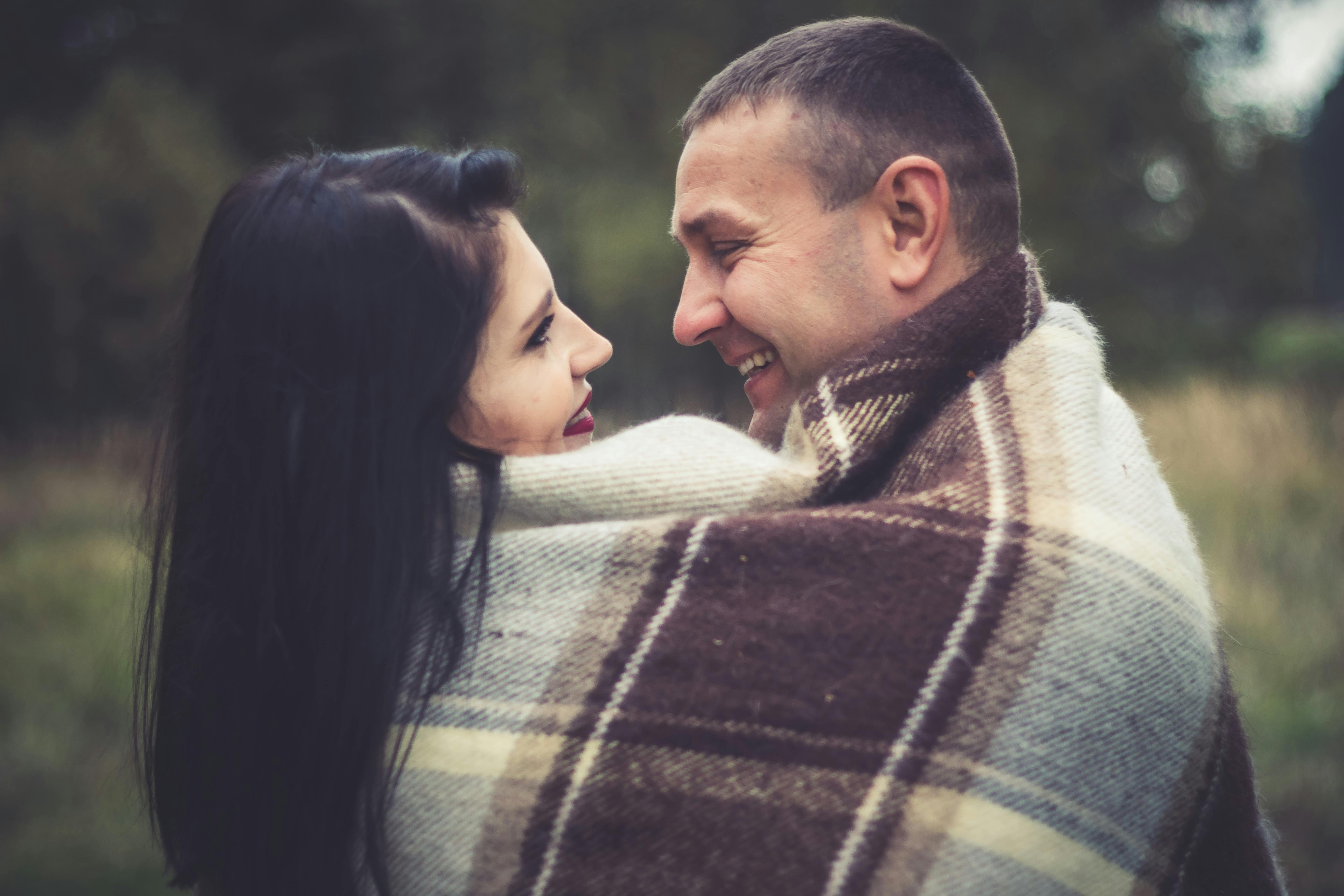 Affectionate Couple Cuddle Under Blanket · Free Stock Photo