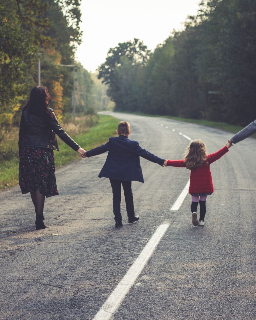 A family walking together down a road, seen from behind