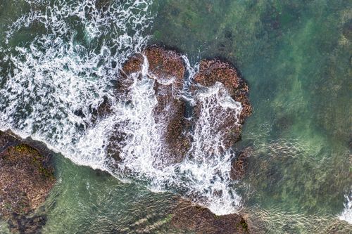 Free A breathtaking aerial view of the ocean waves crashing on rocky shorelines in Banten, Indonesia. Stock Photo