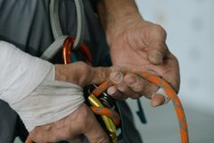 A detailed shot of a rock climber holding rope and carabiner, ready for ascent.