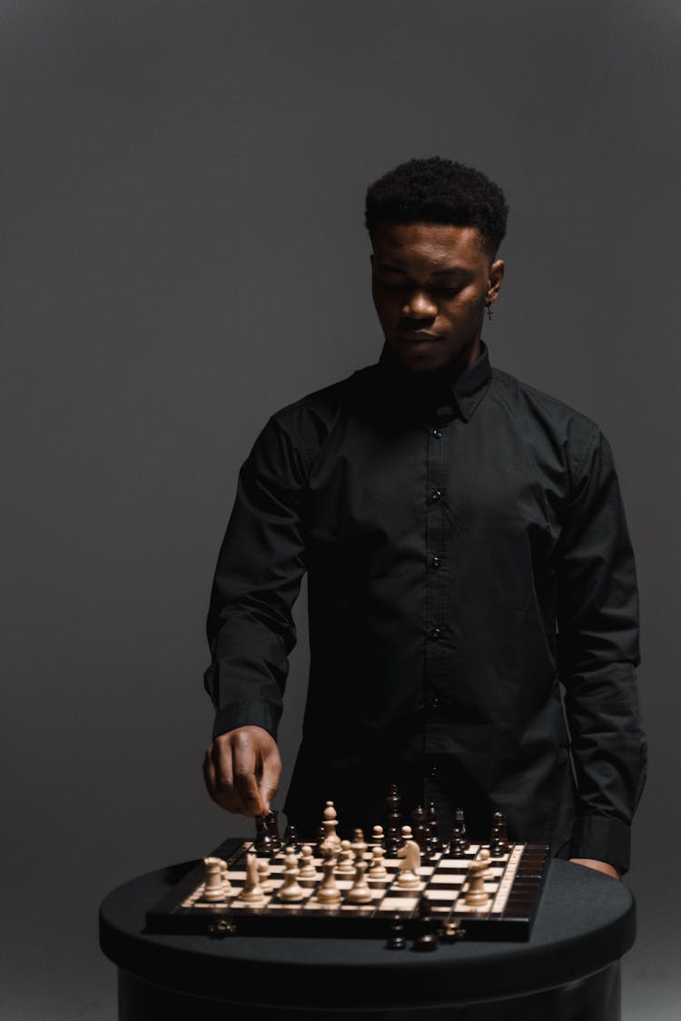 Man In Black Long Sleeves Playing Chess