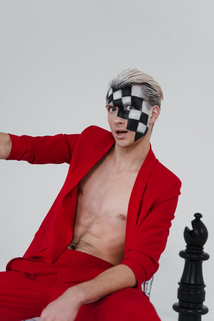 Man In Red Suit Jacket With Checkered Painting On His Face 