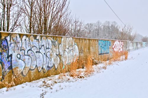 Free Graffiti on a long wall in a snowy outdoor setting, capturing urban winter vibes. Stock Photo