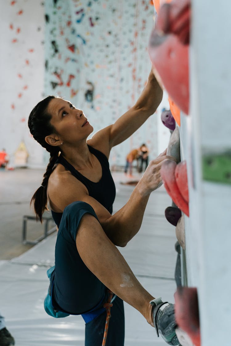 Woman Holding On Climbing Holds