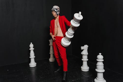 Photo of a Man Posing with a Chess Piece