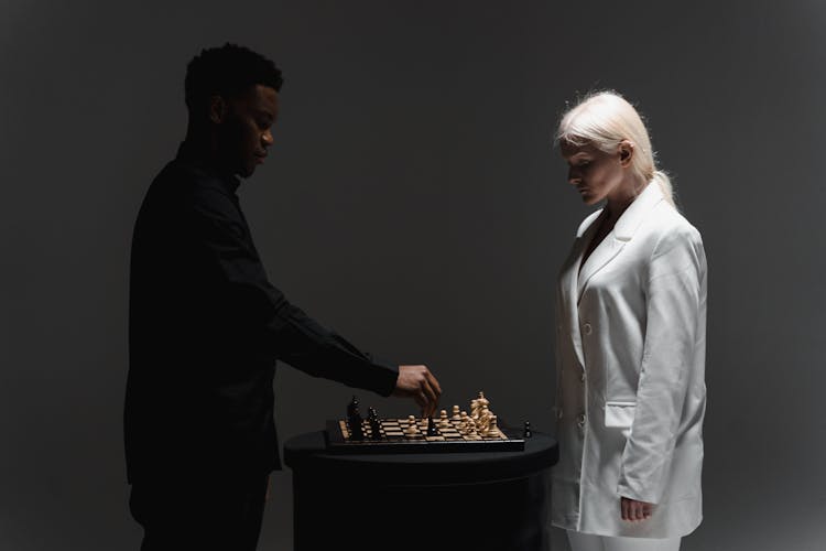 A Woman And A Man Playing Chess