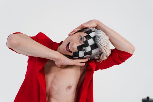 A Man with Black and White Face Paint Posing with His Hands