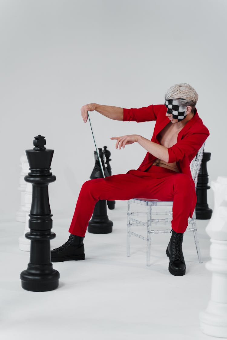 Stylish Man In Red Suit Beside Chess Pieces 