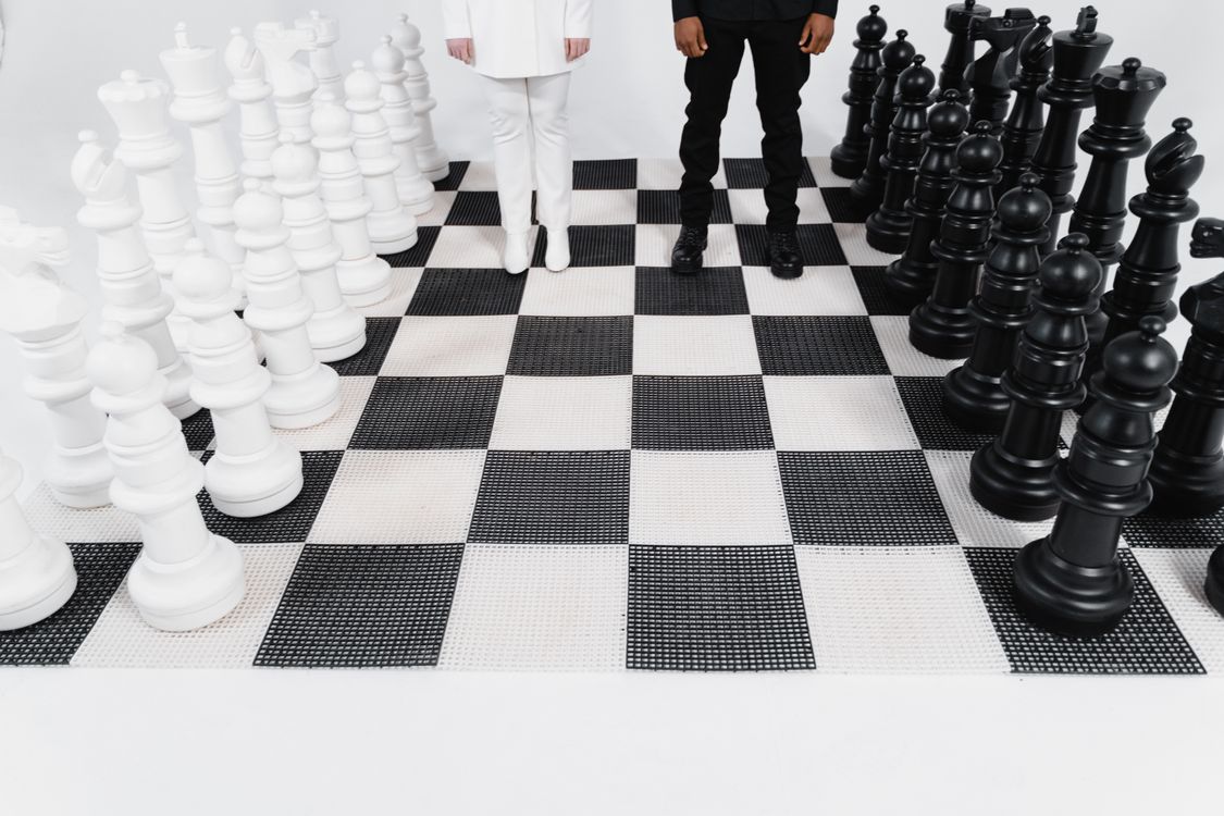 Photo of People's Legs Near Chess Pieces · Free Stock Photo