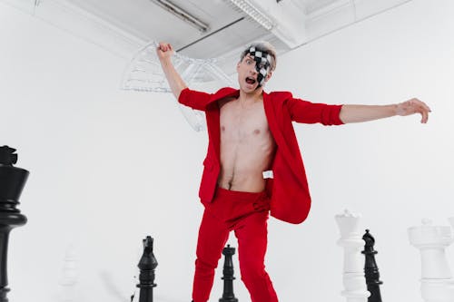 A Shirtless Man in a Red Suit  Holding a Chair