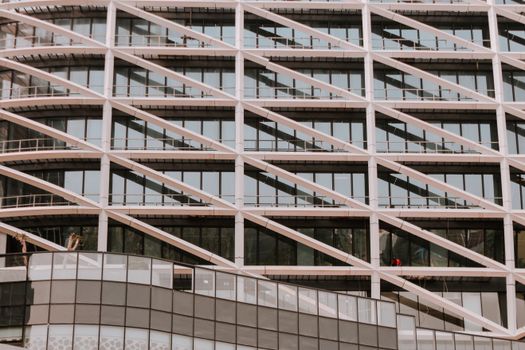 Close-up of a modern building facade featuring diagonal structural elements and large glass windows.