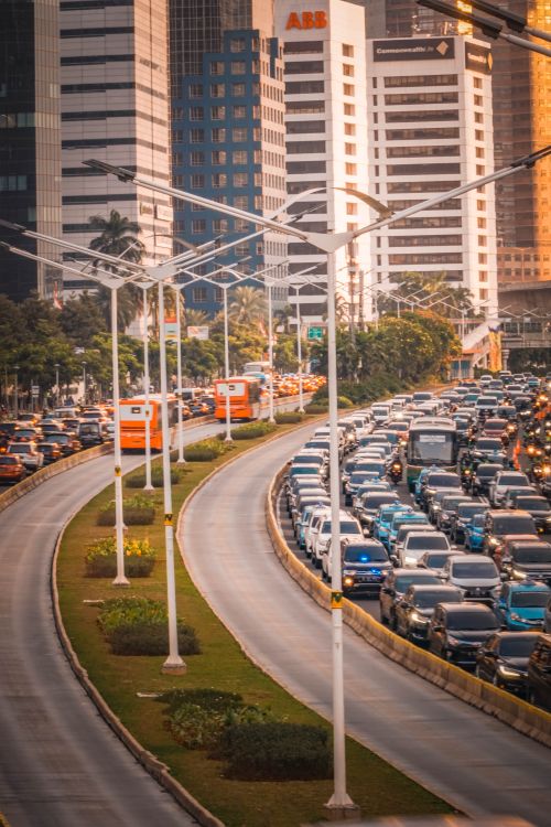 Free Heavy traffic on a Jakarta road with high-rise buildings in the background during sunset. Stock Photo