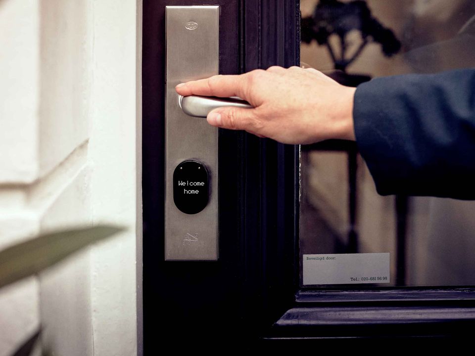 Mano abriendo una puerta con cerradura inteligente de acceso digital