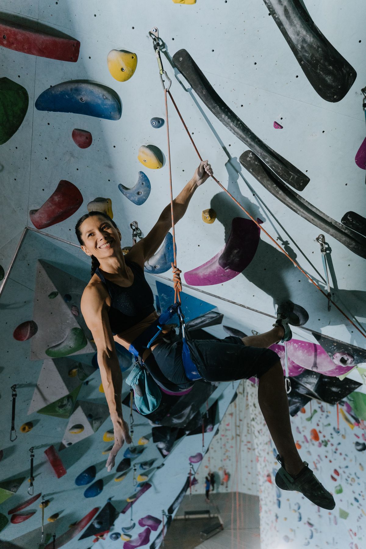 Femme pratiquant l’escalade sur un mur en salle