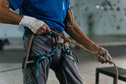 Free Man in climbing gear tying rope for indoor rock climbing session. Stock Photo