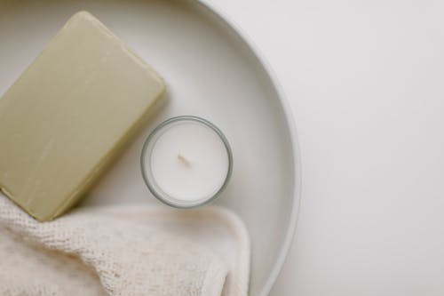 Close-Up Shot of a Soap beside a Candle