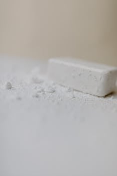 Simple white soap bar with powder on surface, highlighting cleanliness and minimalism.