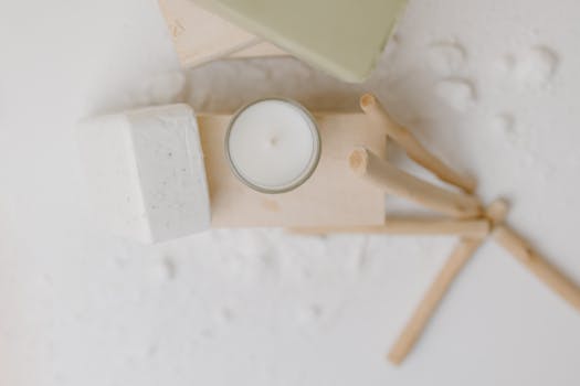 A minimalist arrangement of soap, candle, and wooden elements for a calming, self-care atmosphere.
