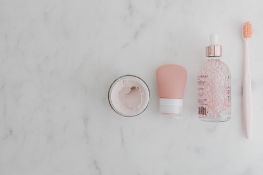 Top view of assorted beauty products on a marble surface with copy space.