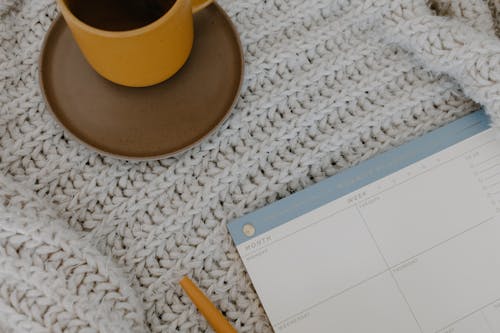 Free Top View of a Weekly Planner on a Knitted Surface Stock Photo