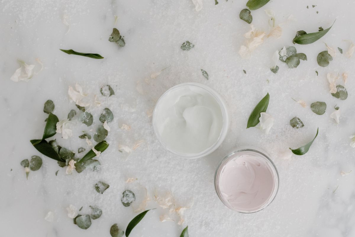 Cream textures surrounded by soft botanical leaves
