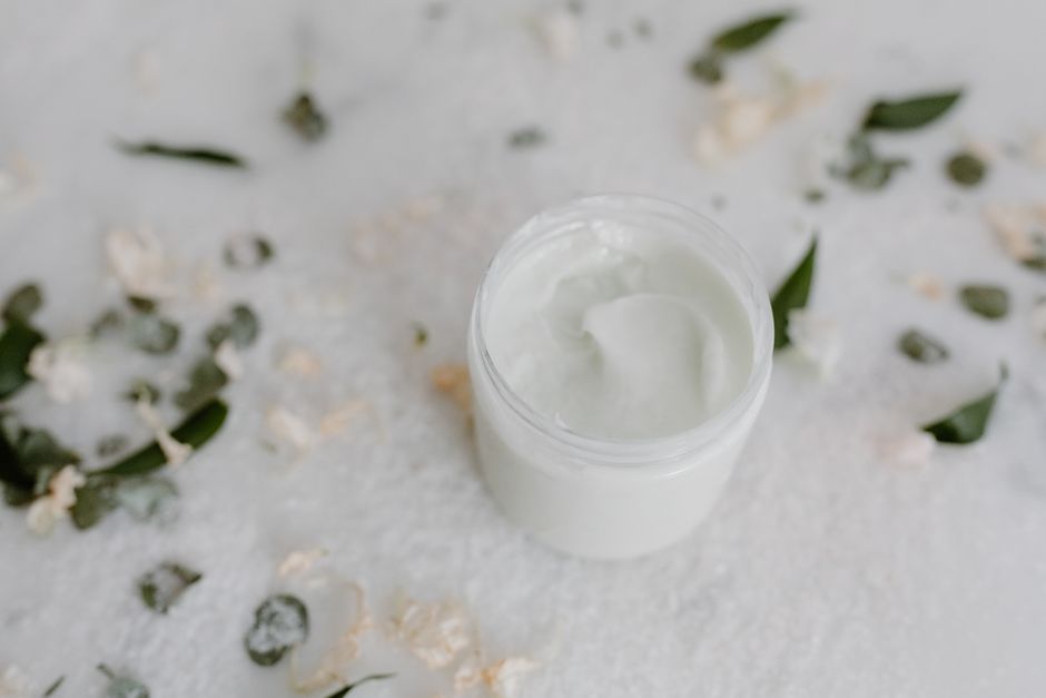 천연 잎으로 둘러싸인 스킨케어 크림 통