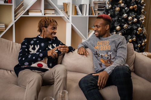Free Two friends laughing and enjoying each other's company on a cozy holiday evening indoors. Stock Photo