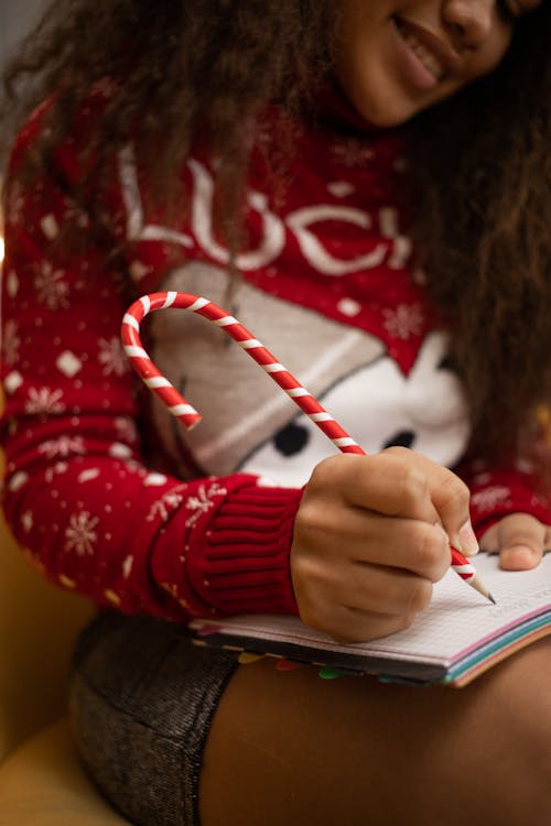 Girl Writing in Notebook with Christmas Pen