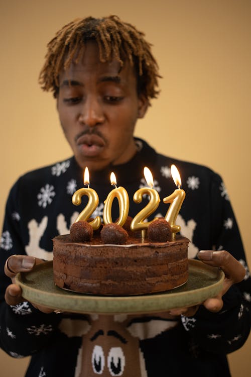 Man Blowing Candles on Cake