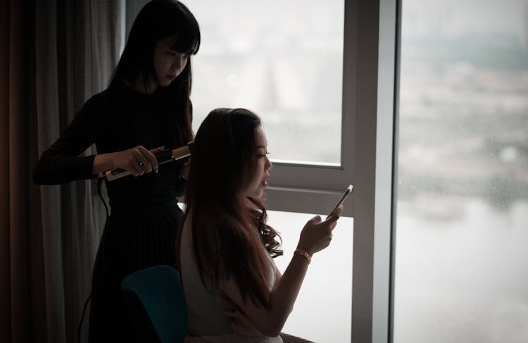 Woman Curling Someone's Hair