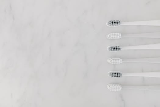 A minimalist image of six toothbrushes arranged on a marble surface, offering a clean and modern aesthetic.