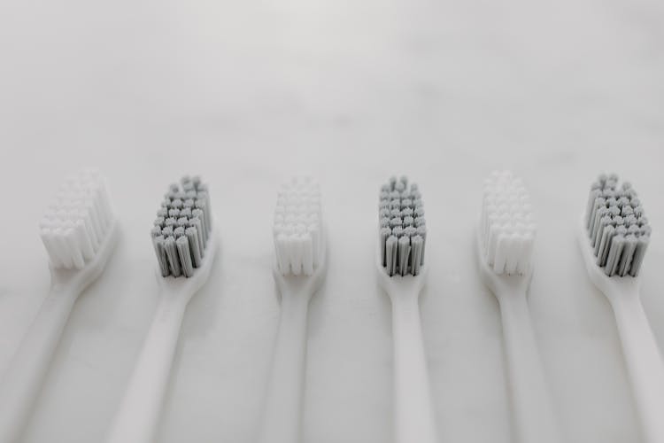 Assorted Toothbrushes Display On White Marble Surface