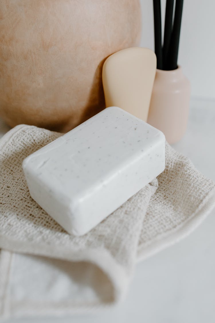 A White Bar Soap On White Towel