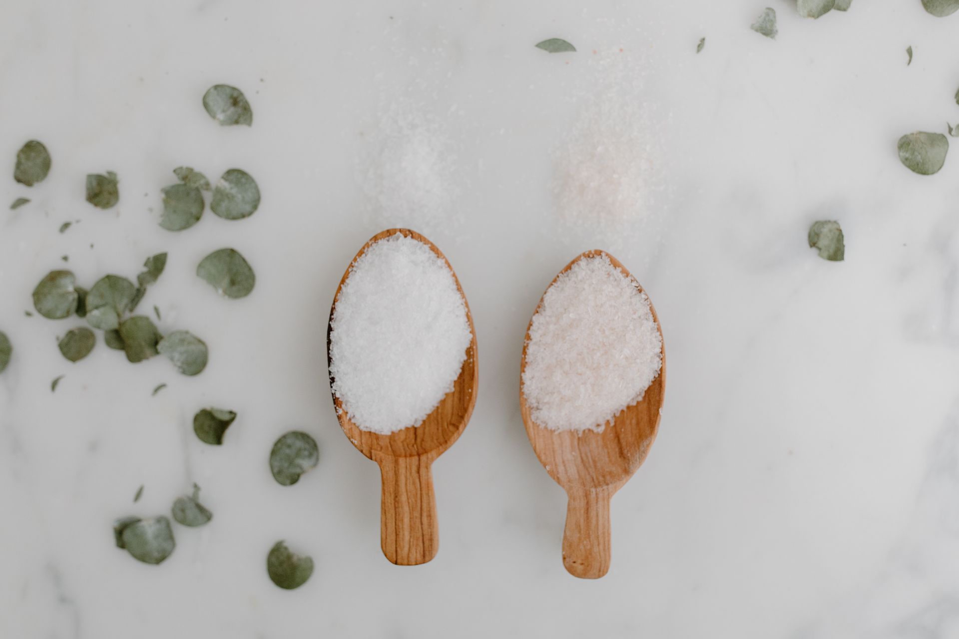 Aesthetic flat lay of wooden spoons with salt, perfect for culinary or lifestyle themes.