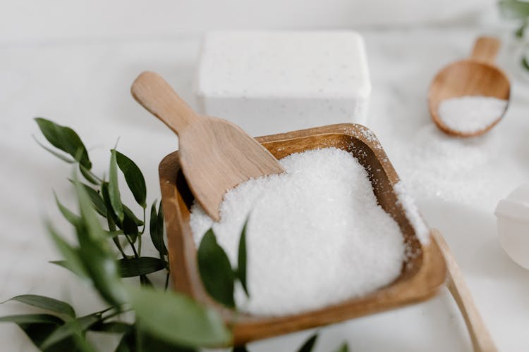 A Wooden Bowl With Rock Salt With Wooden Spoon