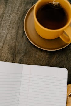Warm cup of tea beside an open notebook, perfect for a cozy morning routine.