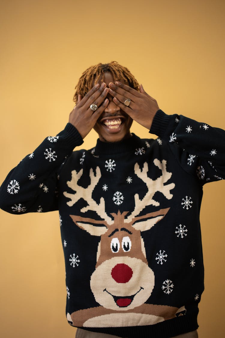 Smiling Man In New Year Sweater Cover Eyes With Hands