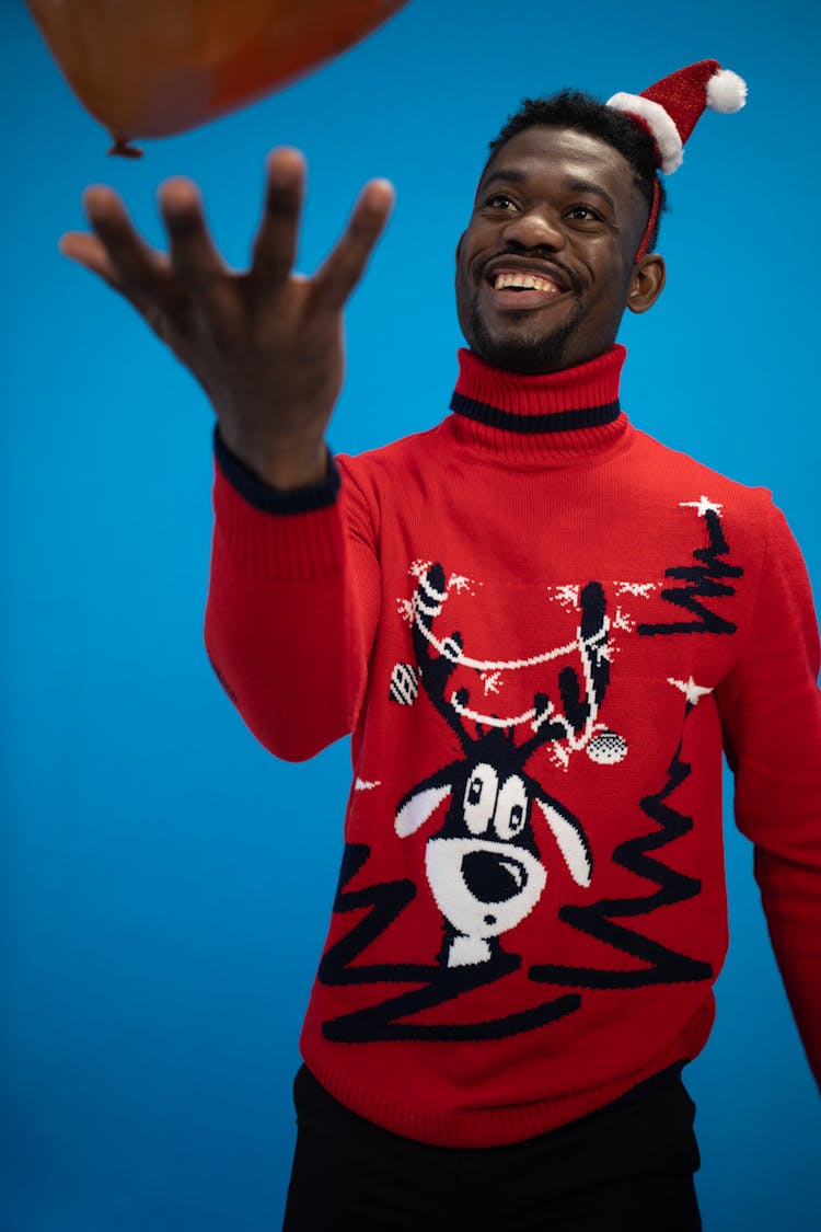A Man With Santa Hat Wearing A Red Ugly Christmas Sweater 