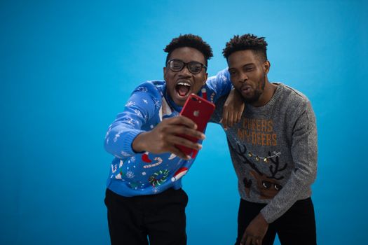 A Pair of Men Wearing an Ugly Christmas Sweaters Taking Selfie