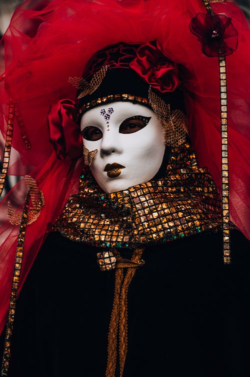 Free Close-up of a detailed Venetian carnival mask adorned with red and gold colors, captured in Venice. Stock Photo