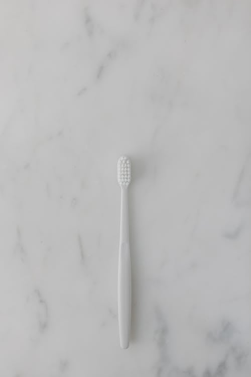 Free Top View of a Toothbrush on a Marble Surface Stock Photo